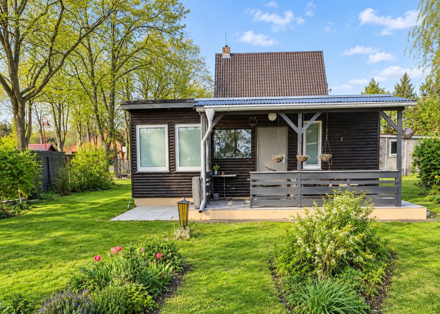 Wochenendhaus mit überdachter Veranda und Terrasse, Blick über den Rasen